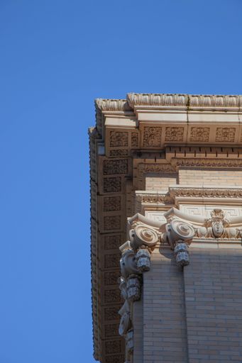A low angle shot of an old building with beautiful sculptures against a blue sky on a sunny day