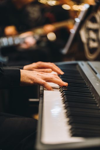 A closeup shot of the hands of a pianist on a piano.