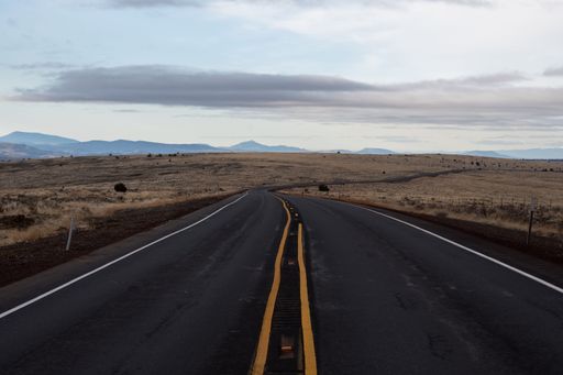 A scenic view of an empty rural road on a sunny day in the countryside