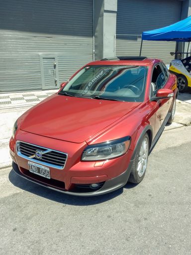 Red Volvo C30 premium compact sport coupe hatchback parked on the sidewalk. Expo Warnes 2022 classic car show.