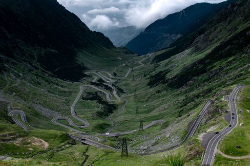 An aerial view of the majestic green mountains and winding Transfagarasan road