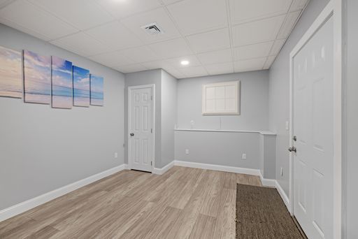 An empty room with a few colorful paintings adorning the walls.