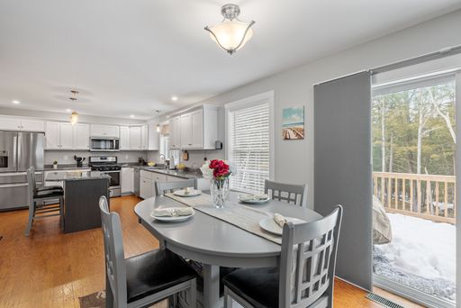 A small gray table with four chairs in the large kitchen setting.