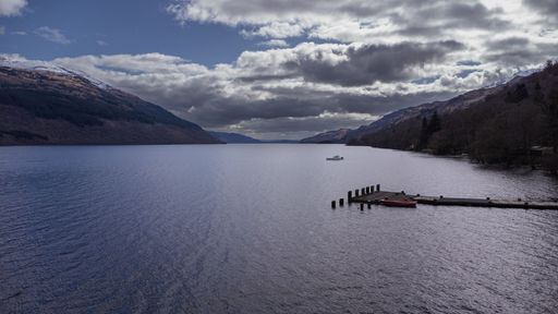 An aerial of a pier on a cloudy day in Loch Lomond, Scotland
