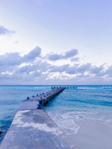 A wooden pier stretching out into the sea on a cloudy day