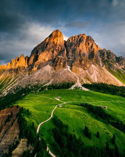 The majestic Italian Alps with rocky peaks, grassy field on the foreground