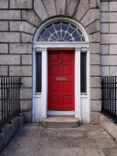 Red arched door of Georgian townhouse in Dublin, Ireland.