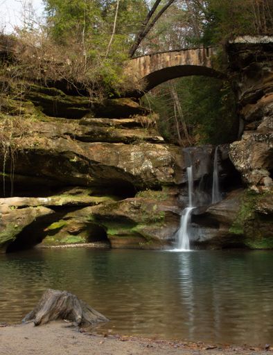 A small waterfall with a stone bridge in Hocking Hills State Park, Ohio