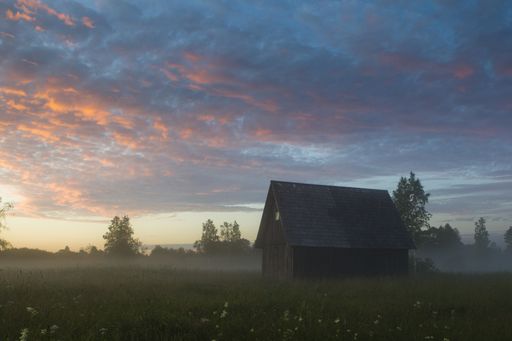A beautiful shot of a wooden cabin in the field