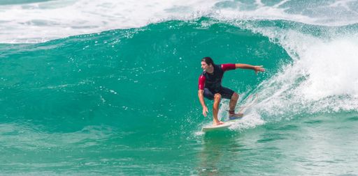 A young caucasian man surfing on the beach in Florianopolis, Brazil