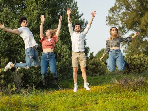 Happy young people jumping and having fun together in the park