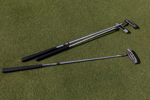 A top view of golf clubs on a green lawn