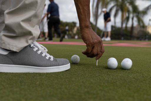 A closeup of a person playing golf on a green lawn