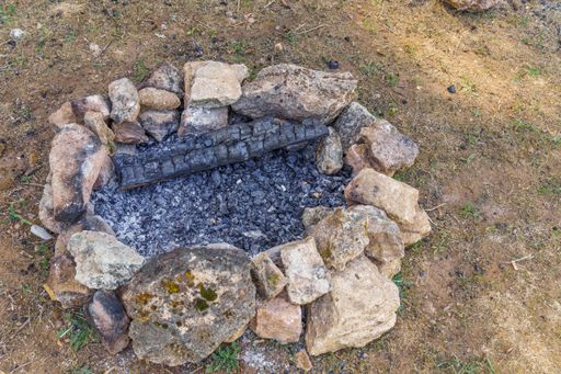 fire extinguished in the field with stones around it, concept cause of fire