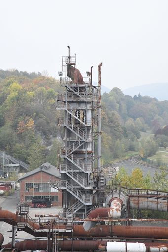 An industrial pipe yard featuring an array of pipes descending down a hillside