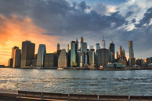 A stunning view of the iconic New York City skyline at sunset, illuminated by the golden sunset