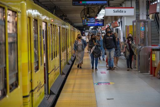 people waiting for the arrival of the subway train on the platform with social distancing