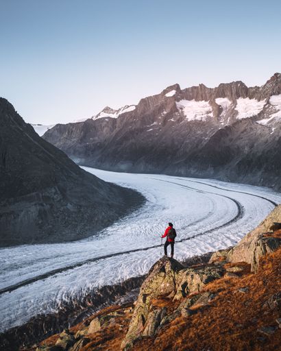A vertical shot of a hiker enjoying the view from the Aletsch glacier in Wallis, Switzerland