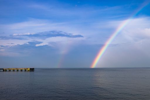 A stunning view of the Downs Park Fishing Pier in Maryland, USA with a rainbow in the backgroudn