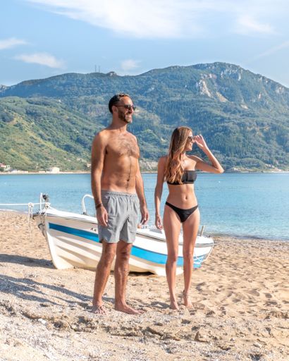 A vertical shot of an attractive beautiful couple on a sunny beach in Croatia