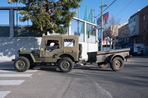 Detail of a military Willys Jeep with trailer on the city street