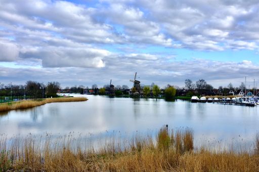 A small Dutch town with windmills and boats along the water