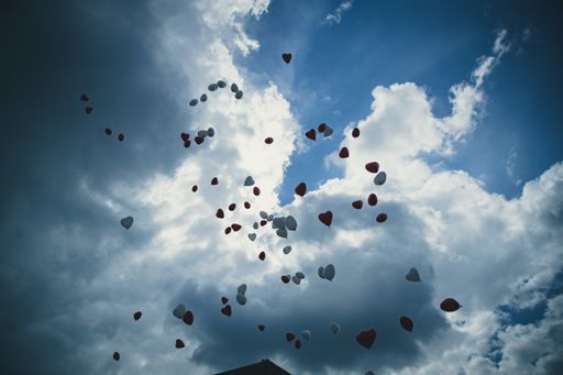 A low angle shot of colorful balloons under a cloudy sky