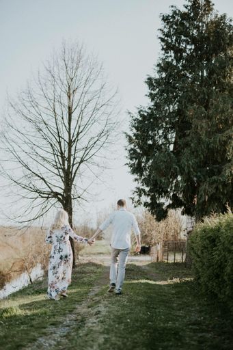 A vertical shot of a married couple walking down the path
