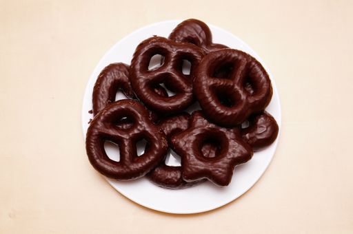 A beautiful shot of cookies covered in chocolate on a white late on a table