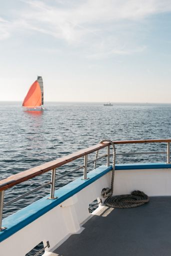 A vertical picture of the sea from a ship under the sunlight and a blue sky