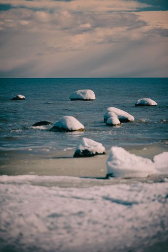 A vertical shot of the frozen seashore under a cloudy sky