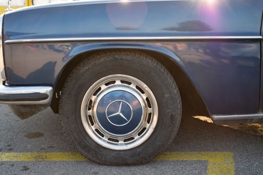 Detail of the wheel of a German luxury classic, it is a blue Mercedes Benz W115 W114