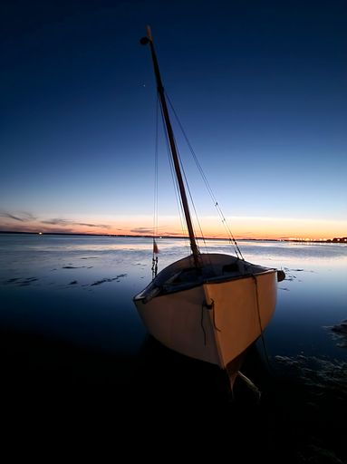 A boat at sunset with a beautiful colored sky.