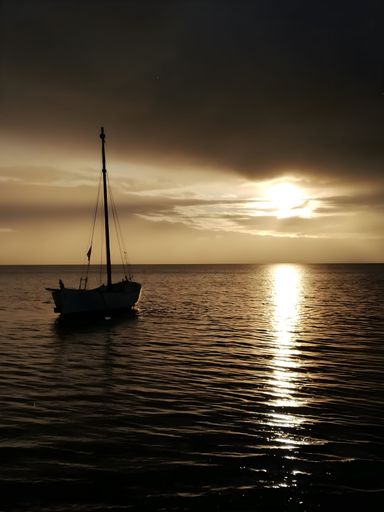 A boat at sunset with a beautiful colored sky.