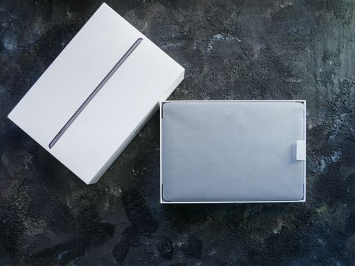 A top view of a gray Apple iPad on a marble background