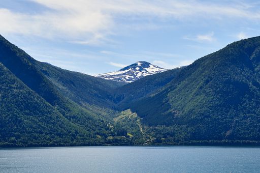 A beautiful shot of Besseggen Ridge in Sognefjord, Norway, with small village at shore near calm water
