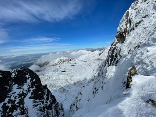 A snowy hill on a picturesque snowy mountain landscape in the Retezat Mountains.