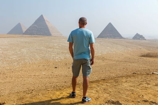 A rear view of a man looking at the famous pyramids of Giza in Egypt