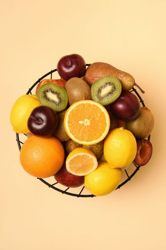 An overhead view of a black metal basket full of fruit