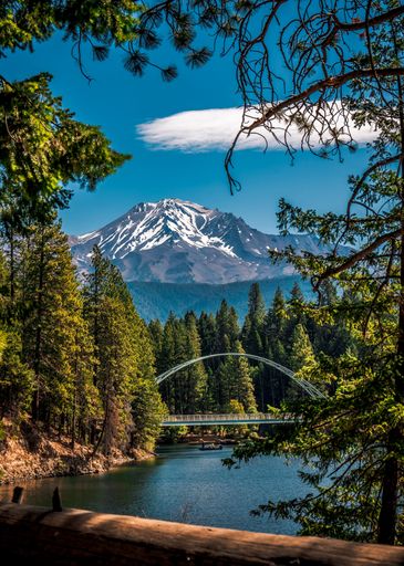 A stunning shot of the Wagon Creek pedestrian bridge in Siskia County, California, with majestic mountains in the background