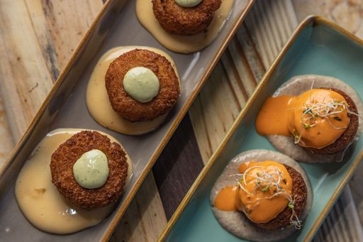 Two trays filled with a variety of deep-fried and sauced dishes presented in an appetizing manner