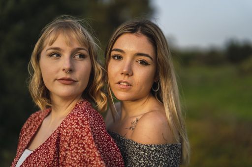 A portrait of two young Caucasian women hugging in a park in Spain
