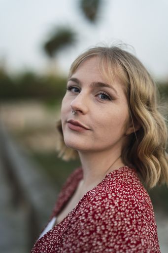 A vertical shot of a beautiful blonde Spanish Caucasian young woman posing in the park