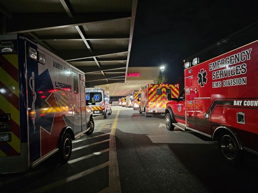 The emergency vehicles parked near the road in a parking lot