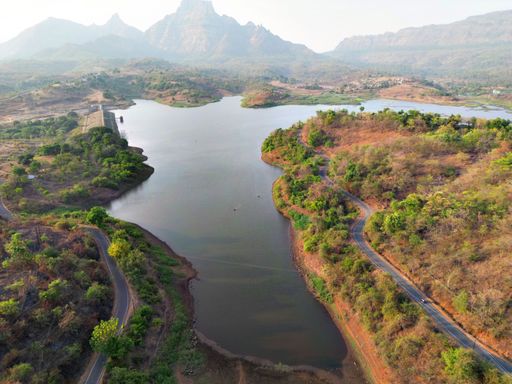Aerial view of a wide river meandering through rolling hills and lush vegetation