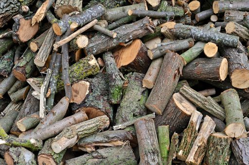 A closeup shot of a stack of freshly cut firewood logs, arranged neatly on top of each other in a pile