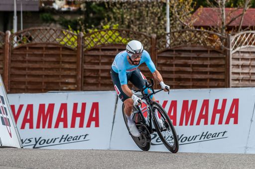 A man riding a bicycle down a lane during a competition