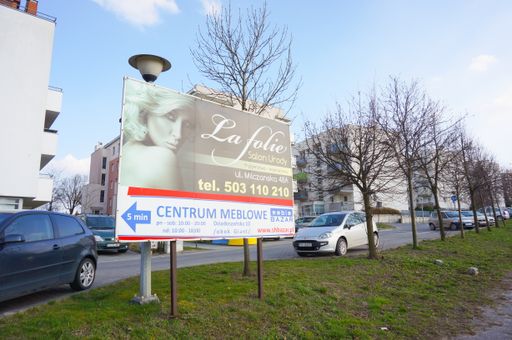 Billboard showing the way to a La Folie beauty salon and Bazar furniture store at the Stary Zegrze area