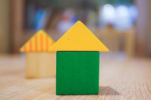 A closeup shot up of toy blocks in the shape of houses set on a table