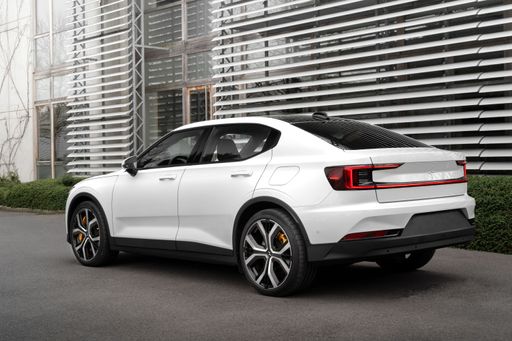 A white Volvo E-Pace parked against a modern building